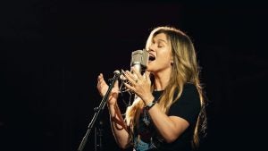a woman singing using a studio microphone